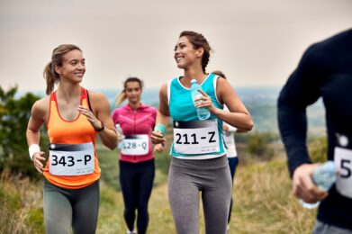 Young happy athletic women running a marathon in nature.